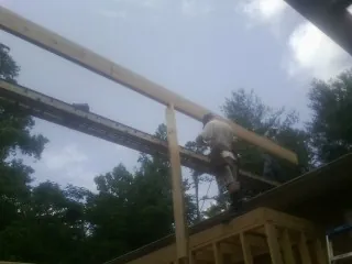 Carpenter setting a ridge beam over a new addition frame — Ice Dam Removal by Roofing Brothers in Grapeview