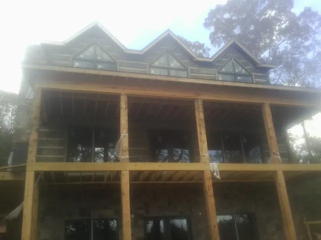 Dormers and porch framing on a large log home under construction — Roof Coating work by our crew in Grapeview